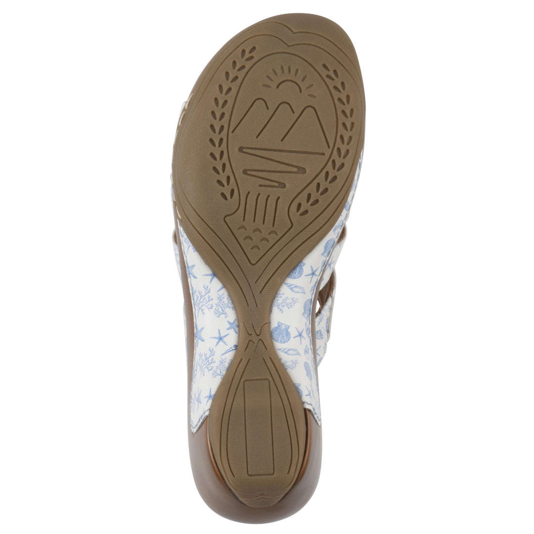 Sole view of an open-toe mule sandal in white with a blue seashell pattern, a cushioned insole, and a brown heel 