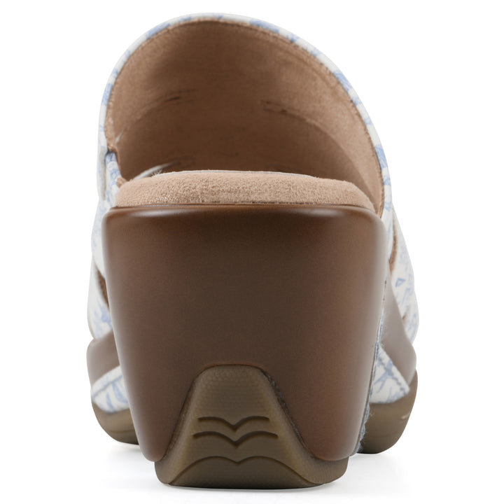 Rear view of an open-toe mule sandal in white with a blue seashell pattern, a cushioned insole, and a brown heel 