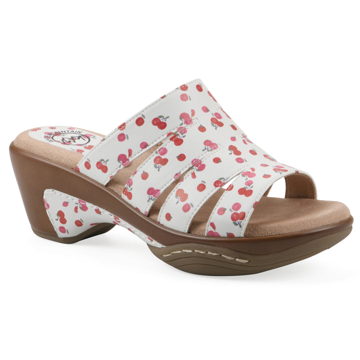 Angle view of an open-toe mule sandal in white with a red cherry pattern, a cushioned insole, and a brown heel 