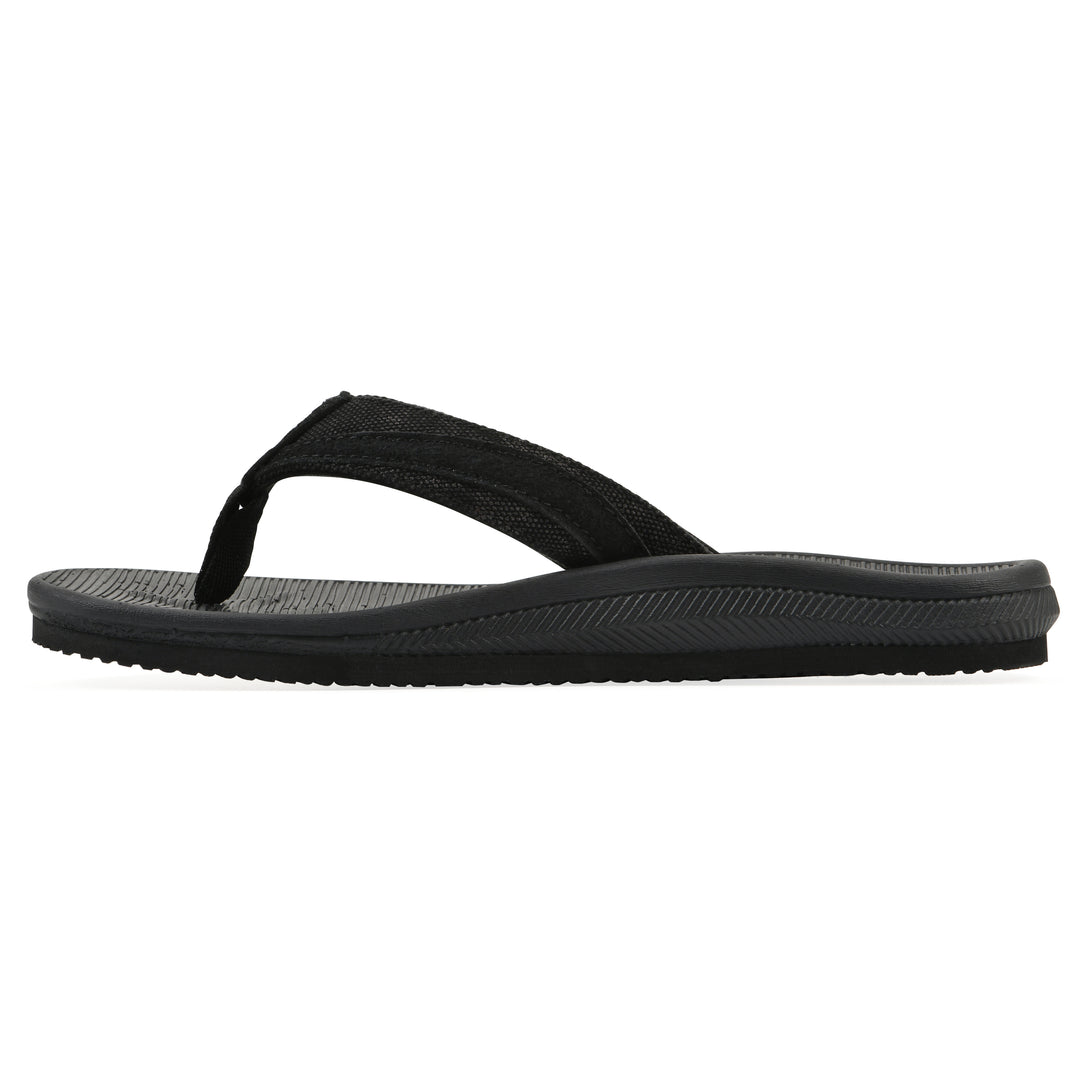 Side view of a cushioned black fabric thong sandal with black patterned sole